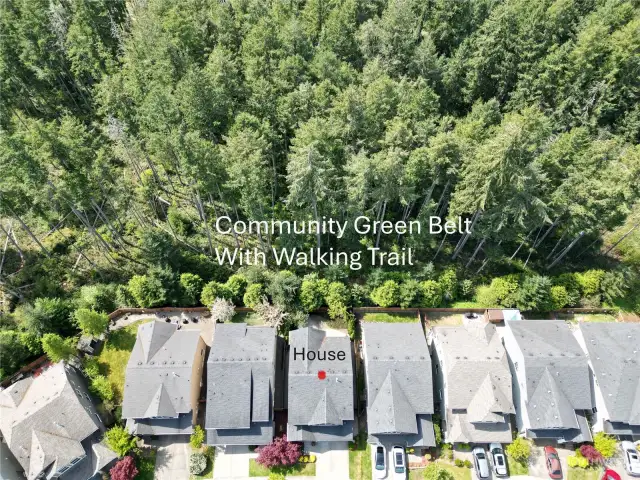 An overview of the home, green belt, and fenced back yard space.