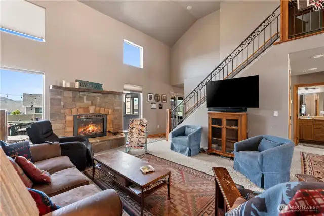Foyer with open floor plan to dining and living room with fireplace