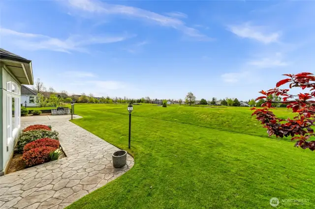 Stamped concrete wraps around with home with tasteful landscaping and lush backyard