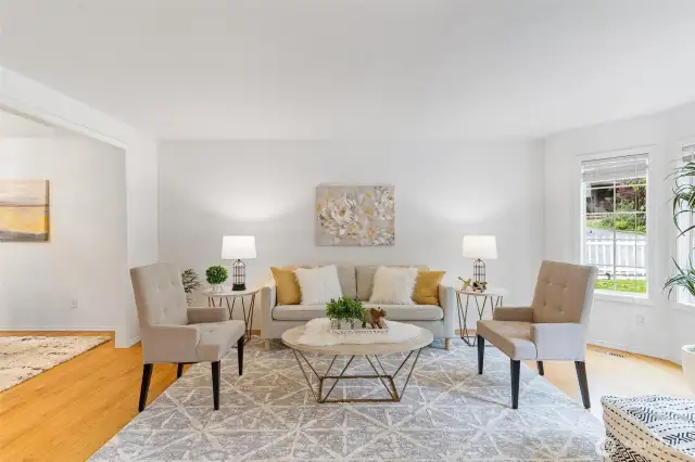 Living room with bay window that lets in the natural light.