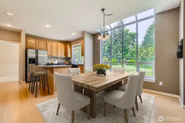The kitchen is open to the breakfast area with its floor-to-ceiling windows that view the park-like grounds.