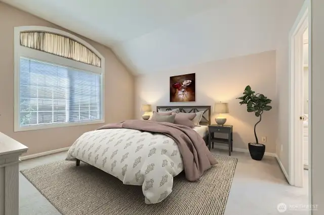 French doors enter into the spacious primary suite with its vaulted ceilings and a large window with an arched top. The 5-piece bath is adjacent.