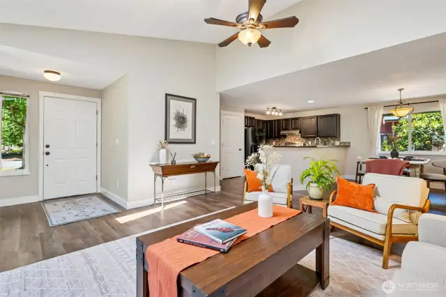 Great view of the living room, entryway, kitchen and dining area.
