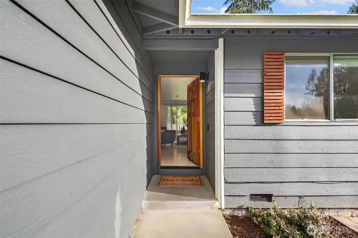 Front entry leading to spacious living room with wood stove.