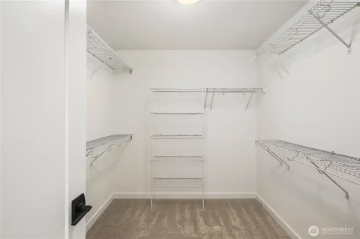 The expansive walk-in closet offers exceptional storage with multiple hanging zones and shelving throughout. Its generous layout supports easy organization and a streamlined morning routine directly off the ensuite bath.    These photos are from lot 3 at Gooden Hollow, the actual home for sale. However, other homes may vary, so all photos, renderings, site maps, and floorplans are for visualization purposes only. Plans, colors, building orientation, finishes, home outlook, and other details can and WILL vary.