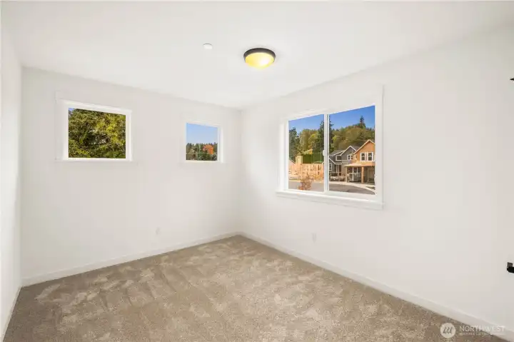 Large windows bring in beautiful natural light and showcase neighborhood and treetop outlooks from this upper-level bedroom. With a spacious footprint and flexible layout, it easily functions as a restful sleeping space or a bright home office.    These photos are from lot 3 at Gooden Hollow, the actual home for sale. However, other homes may vary, so all photos, renderings, site maps, and floorplans are for visualization purposes only. Plans, colors, building orientation, finishes, home outlook, and other details can and WILL vary.
