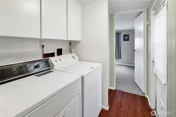 Working laundry area with Realtor-tested washer and dryer and ample storage.