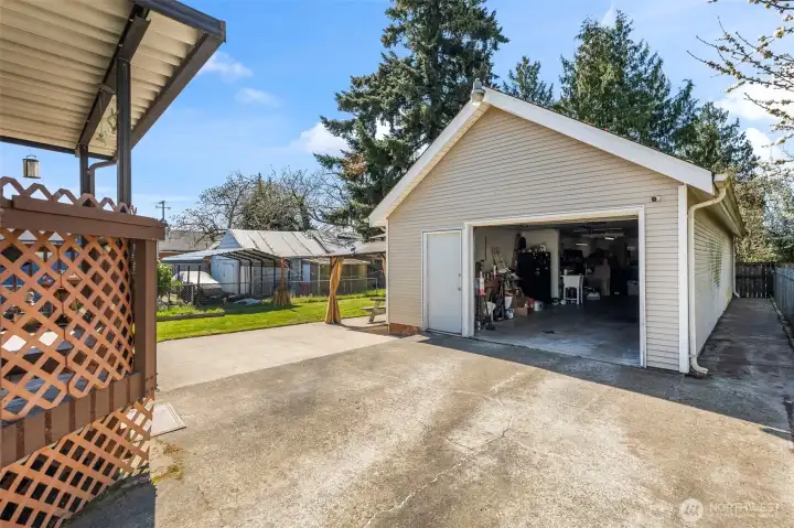 The covered back patio and detached four car garage.