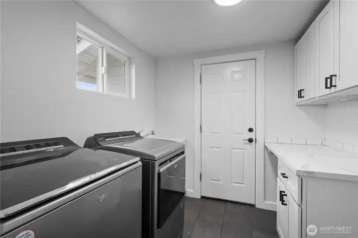 Laundry room with utility sink and garage access.