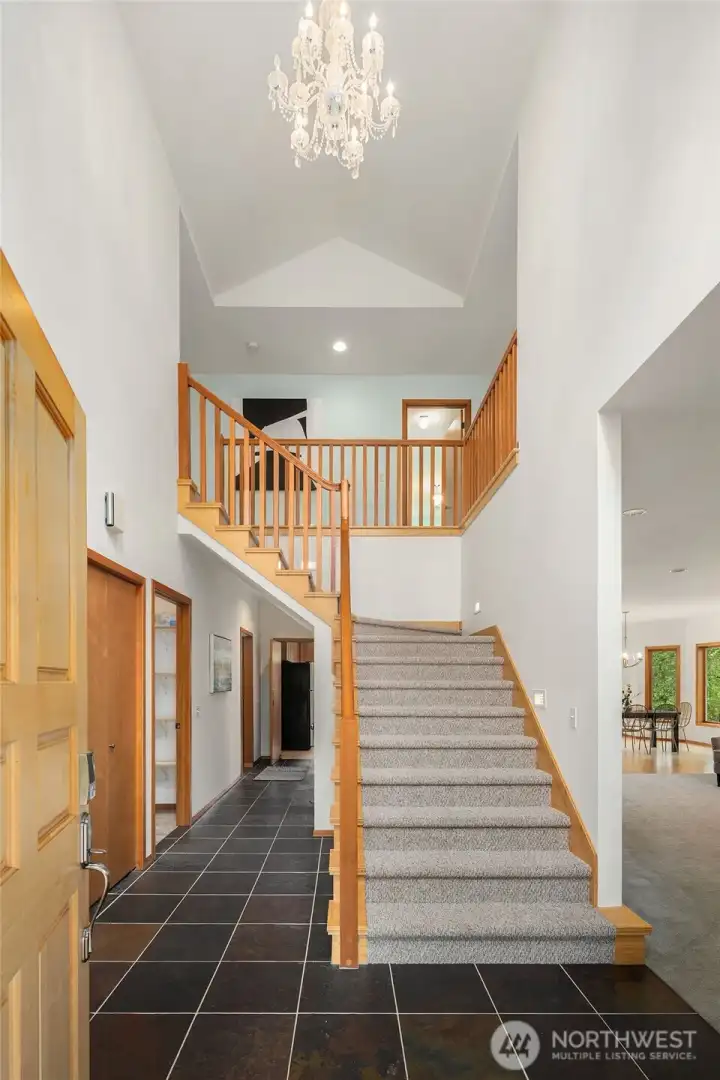 Entry way with soaring ceilings and extra-wide staircase.