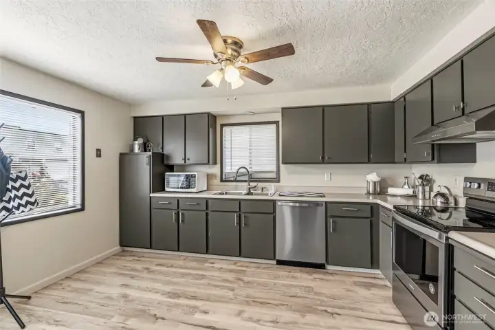 Fully modernized kitchen featuring new cabinetry, sleek countertops, updated flooring, and brand-new appliances and light fixtures