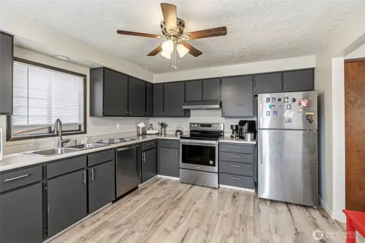 View from the dining area looking into the fully updated kitchen, highlighting the brand-new appliances and seamless layout
