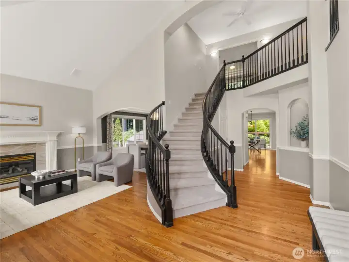 An unforgettable first impression begins in the grand two-story foyer, where a graceful curved staircase, soaring ceilings, and rich hardwood floors create timeless elegance. This welcoming entry beautifully introduces the home's refined living spaces. An unforgettable first impression begins in the grand two-story foyer, where a graceful curved staircase, soaring ceilings, and rich hardwood floors create timeless elegance. This welcoming entry beautifully introduces the home's refined living spaces.
