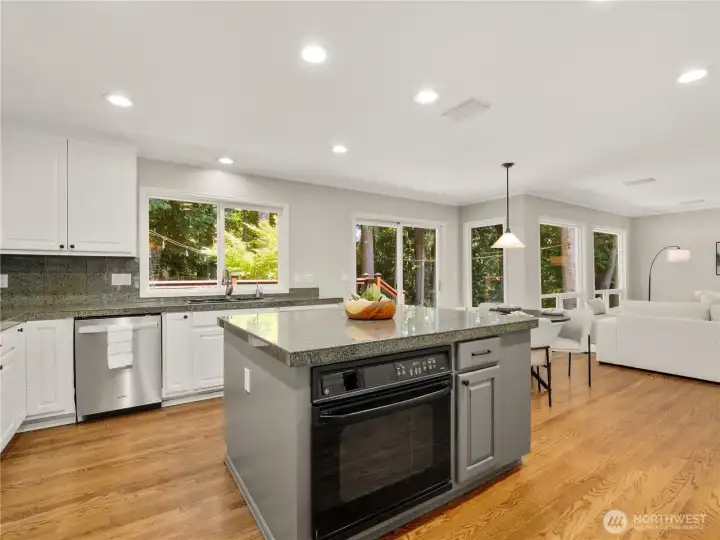 A spacious center island, abundant prep space, and expansive windows bring everyone together while showcasing peaceful views of the surrounding greenery. A spacious center island, abundant prep space, and expansive windows bring everyone together while showcasing peaceful views of the surrounding greenery.