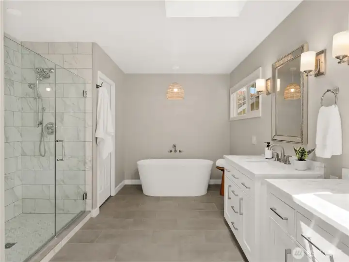Escape to a spa-inspired primary bath featuring a freestanding soaking tub, an oversized glass-enclosed shower with marble-look tile, and timeless finishes throughout. Escape to a spa-inspired primary bath featuring a freestanding soaking tub, an oversized glass-enclosed shower with marble-look tile, and timeless finishes throughout.