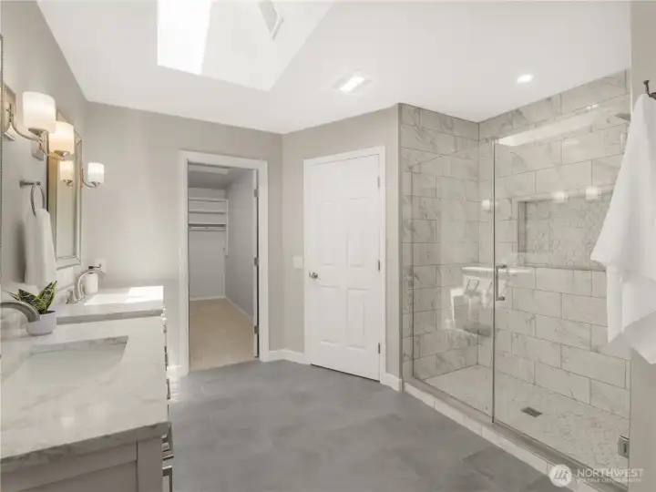 Every detail of the primary bath has been thoughtfully designed, from the expansive glass-enclosed shower with elegant marble-look tile to the dual quartz vanities and seamless connection to the walk-in closet. Every detail of the primary bath has been thoughtfully designed, from the expansive glass-enclosed shower with elegant marble-look tile to the dual quartz vanities and seamless connection to the walk-in closet.