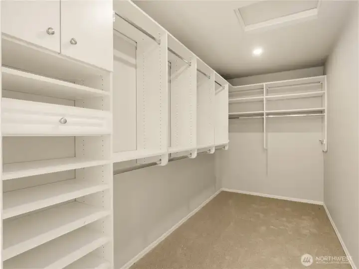 Designed with both style and practicality in mind, the expansive walk-in closet features custom built-in organization, adjustable shelving, dedicated hanging space, and abundant storage. Designed with both style and practicality in mind, the expansive walk-in closet features custom built-in organization, adjustable shelving, dedicated hanging space, and abundant storage.
