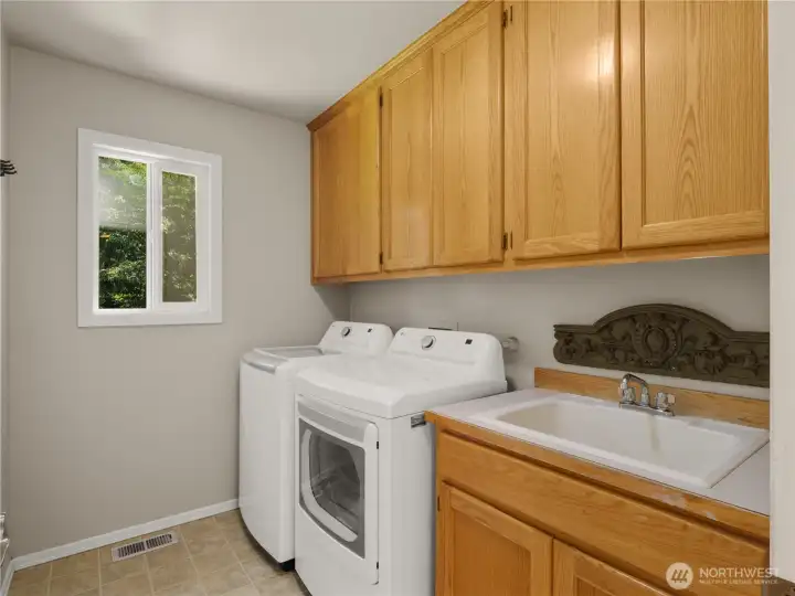 Designed for everyday ease, the spacious laundry room features abundant cabinetry, a utility sink, and generous workspace, making household tasks both practical and organized. Designed for everyday ease, the spacious laundry room features abundant cabinetry, a utility sink, and generous workspace, making household tasks both practical and organized.