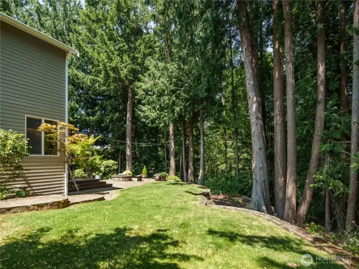 Bordered by majestic evergreens, the private backyard offers a picturesque, park-like setting with lush lawn space. Bordered by majestic evergreens, the private backyard offers a picturesque, park-like setting with lush lawn space.
