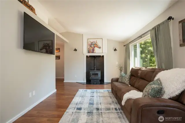 The vaulted ceilings & cozy woodstove are special details of this welcoming home!