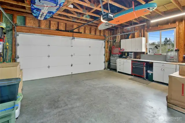 Neat and clean garage with storage space/work bench.
