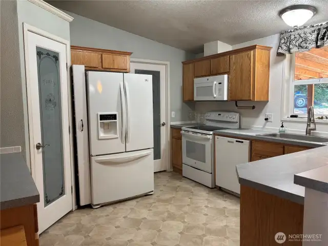 Kitchen is light and bright, offering a walk-in pantry with labeled door and lots of space.