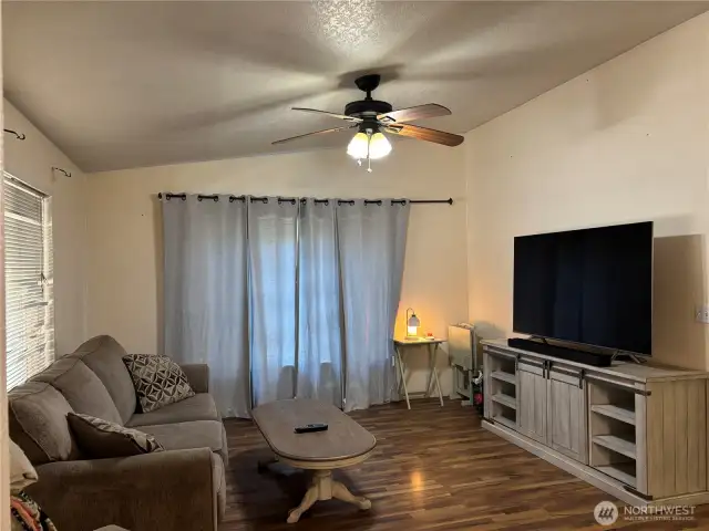 Rec room off the dining room, offering vaulted ceilings and a fan.