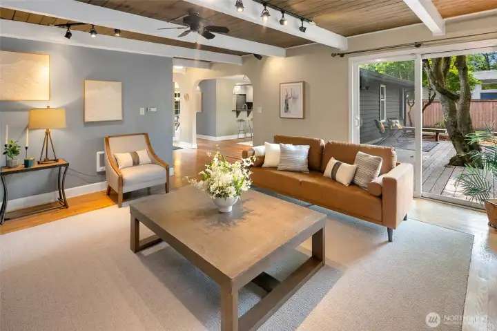 Living room features new carpet, hardwoods, gas fireplace, and built-in shelving which remains.... sliding doors to the expansive deck.