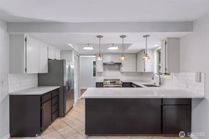 Kitchen with eating bar, new lighting, counters,sink and tiled floors