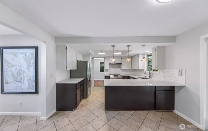 Kitchen with eating bar, new lighting, counters,sink and tiled floors