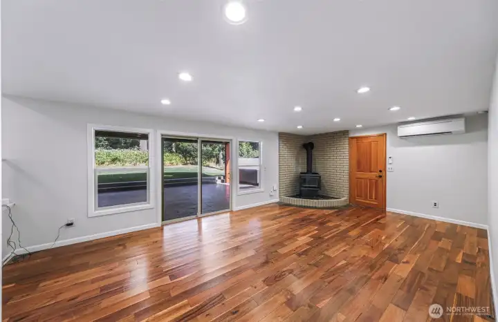 Lower level living room with stunning flooring, real wood stove, access to garage and Chalet covered back patio