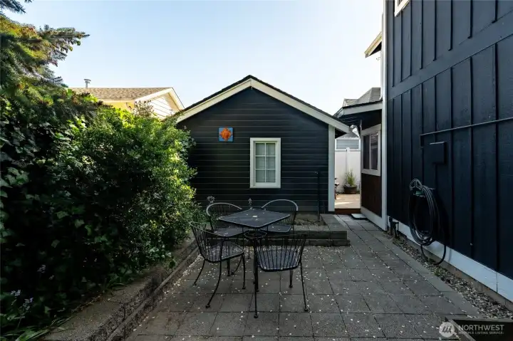 A view of the private patio behind the home with the standalone room.