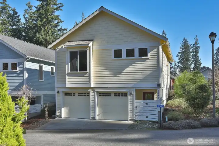 Oversized two car garage with side covered areas for recycling, toters or yard equipment.