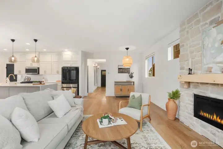 The main living area opens directly to the kitchen, creating a true open-concept layout ideal for everyday living and entertaining. Large windows bring in natural light while the expansive sightlines connect the gathering spaces throughout the main floor.