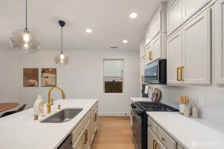 Functional kitchen workspace with generous counter space, upper cabinetry for storage, and modern appliances positioned for efficient everyday cooking. The layout keeps prep areas organized while maintaining sightlines to the rest of the main living space.