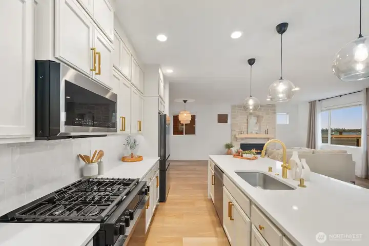 From the kitchen, the home’s open-concept layout comes into full view, connecting the cooking space with the living room and fireplace feature wall. This vantage point highlights how easily the main living areas work together for daily life and entertaining.
