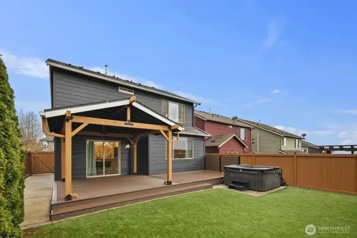 Full view of the backyard highlighting the large covered deck, private fencing, and neatly maintained yard space. The layout offers room for outdoor seating, entertaining, and everyday enjoyment just steps from the home.