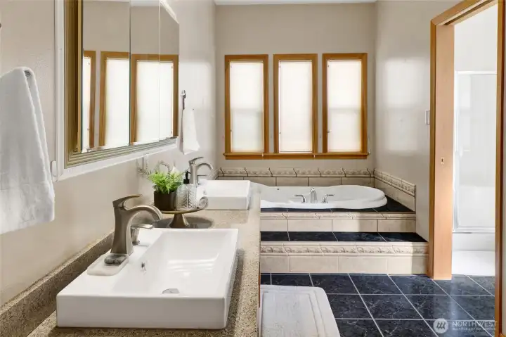 The primary bath features double sinks, a soaker tub, and a separate shower