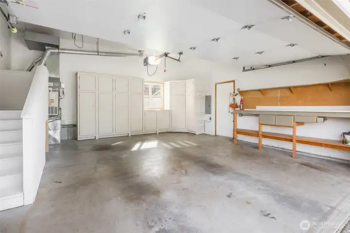 Clean garage with extra storage space above and room for more