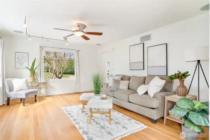 Large windows fill the living room with sunlight, creating a bright and inviting space.