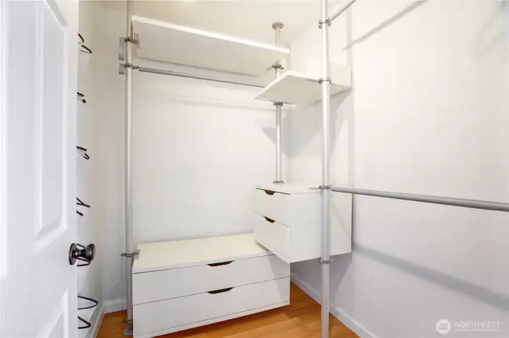 The walk-in closet features a built-in system with drawers and hanging space for easy organization.