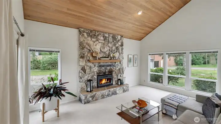 Vaulted ceilings and the floor-to-ceiling stone fireplace make a dramatic statement in the living room.