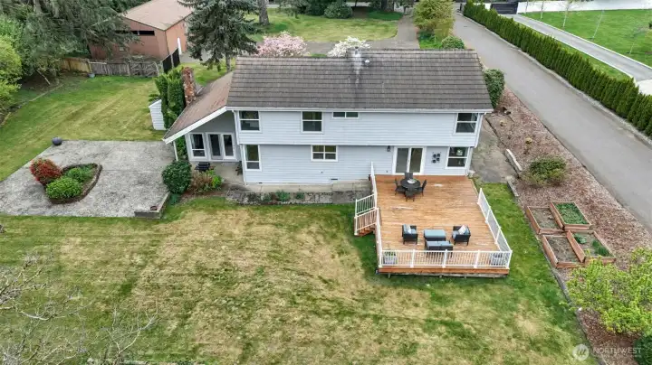 Over 1 acre of level yard with mature landscaping, planting beds, large deck, and patio.