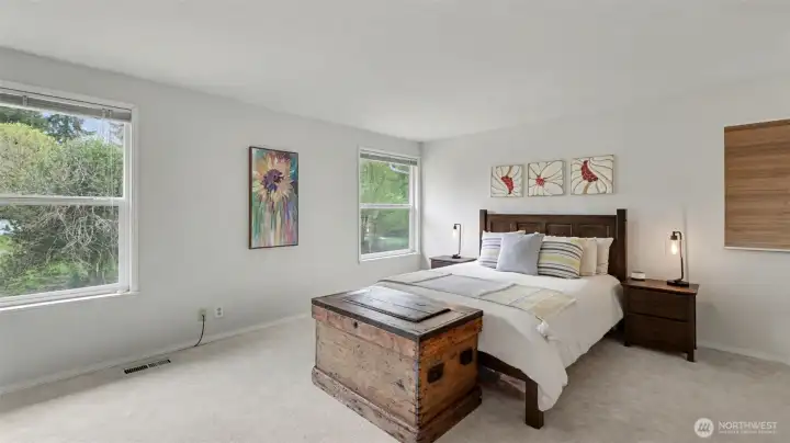 Generous primary suite features a wall of windows, walk-in closet and updated bath.