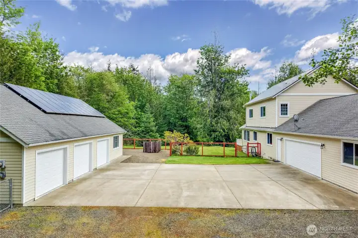 A large central parking pad separates the home and 3 car, oversized garage
