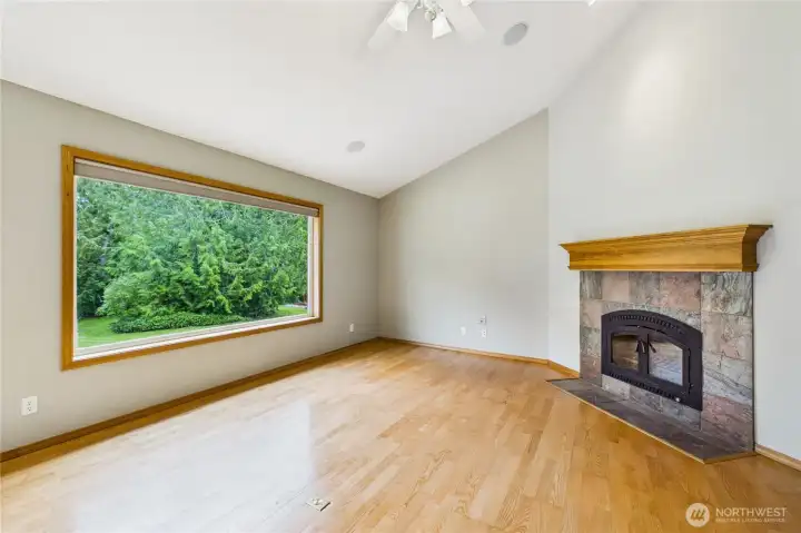 Large pane windows open up to nature throughout the home, this is looking toward the living room from the kitchen.