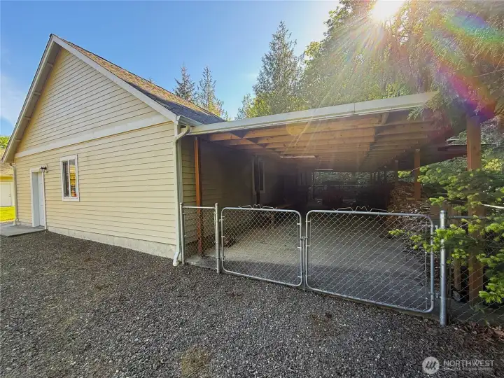 Entensive covered concrete pad under cover for additional storage and easy access behind 3 car detached garage.