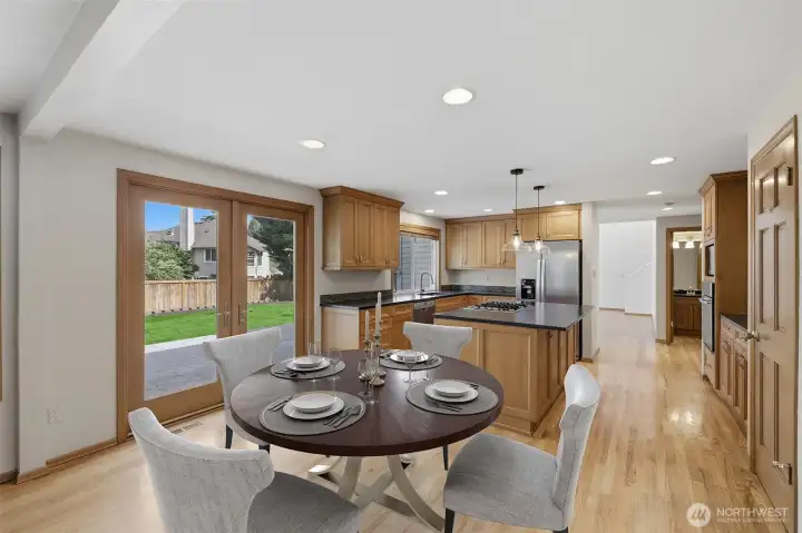 Dining nook next to kitchen with french doors leading to large exterior patio. Virtually staged