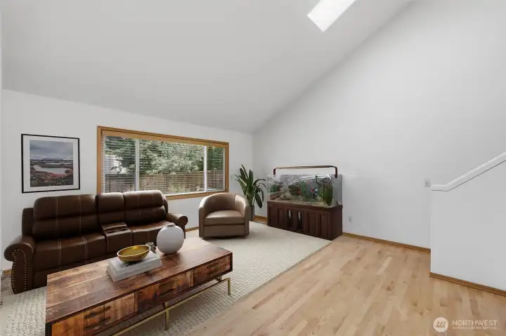 Main floor family room has soaring vaulted ceilings with two skylights letting in an abundance of natural light. virtual staged