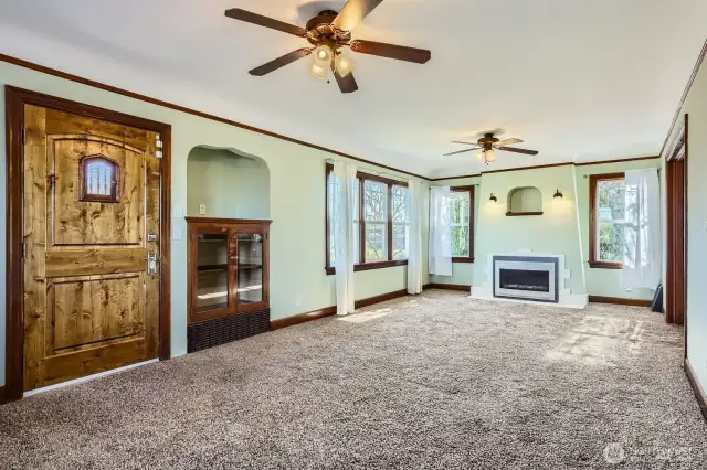 Large living room w/ cozy insert gas fireplace, ceiling fans & beautiful built ins.